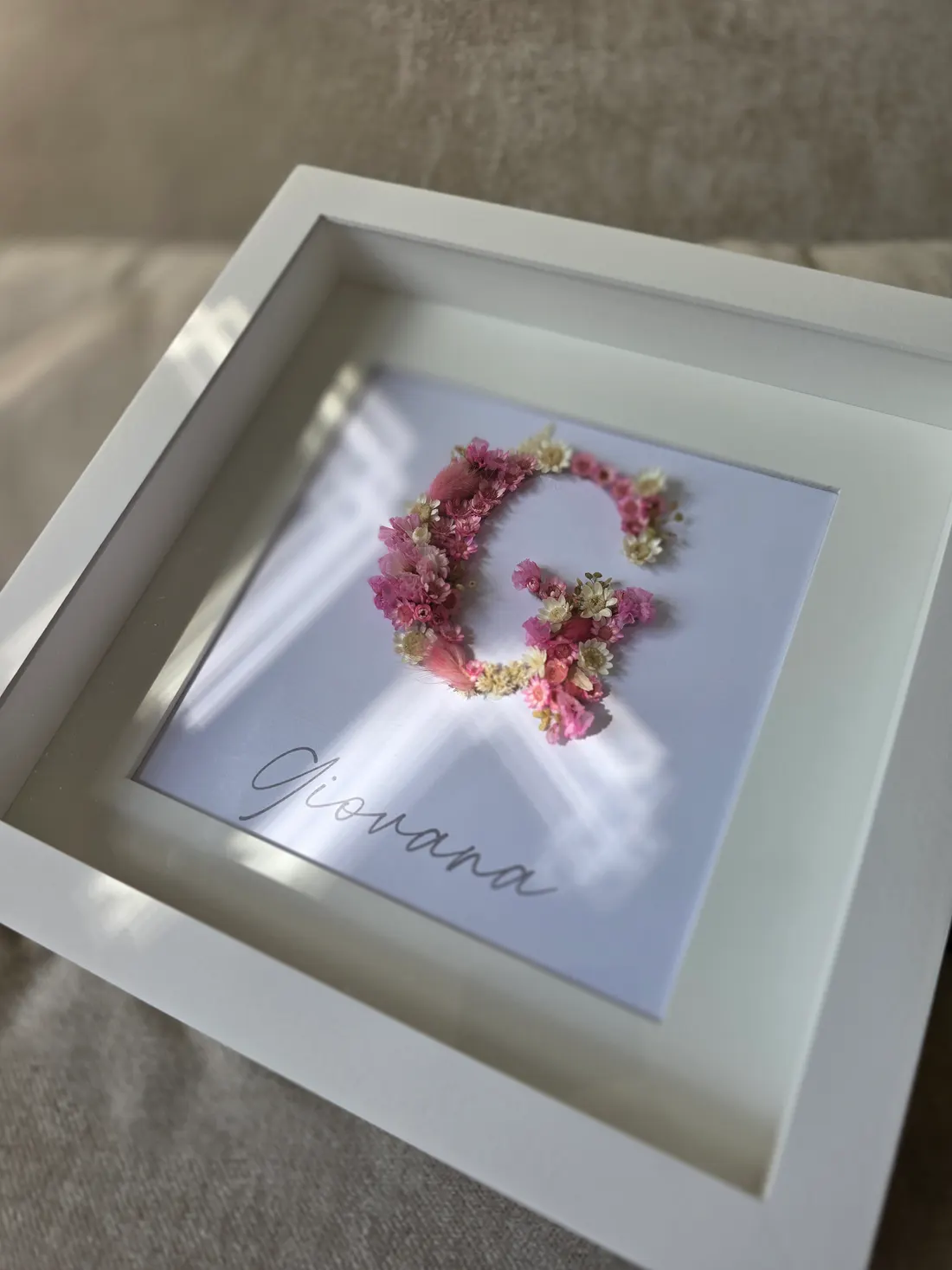 Detalhe em ângulo do quadro floral mostrando o relevo das flores